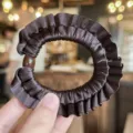 Brown satin ruffled hair scrunchie detail close up view, elegant elastic hair tie accessory - Dark Brown