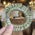 Scrunchie per capelli in raso verde con volant e dettaglio di perla grigia, dettaglio. - Verde