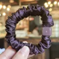 Dark purple satin hair scrunchie with matching square charm, close-up hair accessory detail. - Deep purple