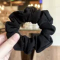 Vista detallada de coletero de pelo de tela negra, accesorio elegante y minimalista. - Negro