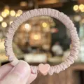 Eleganter koreanischer Satin Haargummi mit rosafarbenem Herz Anhänger, Detailaufnahme. - Rosa