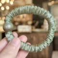 Détail de chouchou en satin avec perle, corde à cheveux élastique élégante femme. - Vert