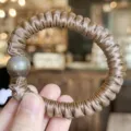 Vue détaillée de l'élastique à cheveux en satin avec perle foncée, haute élasticité. - Café Clair