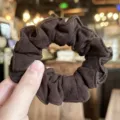 Detail close-up of brown textured hair scrunchie, elastic fabric design for daily sweet hair styling. - Dark Brown