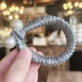 Vue détaillée d'chouchou en satin gris avec ornements de perles doubles et design plissé. - Gris Bleu