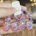 Detailed close-up of cute children glitter bow hair tie in purple, sparkling resin accessory. - Purple