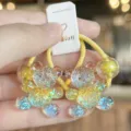 Detailed close-up of glitter resin bear hair ties with bright yellow elastic band and cute design. - Yellow
