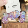 Purple sparkly bow hair tie close-up detail showing glossy resin charms and glitter effect. - Purple
