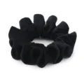 Black velvet hair scrunchie with pleated edge detail, soft plush fabric for elegant ponytails. - Black