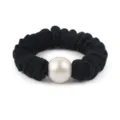 Detail view of black wool scrunchie with large white pearl hair accessory for women. - Black