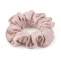 Primo piano dettagliato di un morbido scrunchie in lana rosa, trama soffice per acconciature. - Rosa