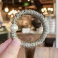 Detail close-up of a satin scrunchie with a large pearl, elegant hair tie for women and girls. - S / Grey Green