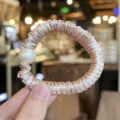 Detail view of the elegant satin hair scrunchie featuring a large white pearl decoration. - S / Light Pink