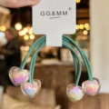 Groene haarelastiekjes met glanzende regenboog hart hangers op displaykaart, schattig. - Groen