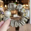 Close-up detail of elegant satin scrunchie featuring a large pearl design accessory. - L / Grey Green