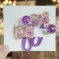 Detailansicht niedlicher Kinder Haargummis mit glitzernden Schleifen und lila Bändern. - Lila
