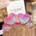 Gros plan détail de l'élastique à cheveux cœur rose pailleté, design résine étincelant enfants. - Rose rouge