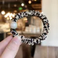 Detailed close-up of a stylish leopard print hair scrunchie with a large faux pearl. - S / Beige Brown Leopard
