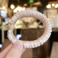 Close-up detail of champagne satin scrunchie hair tie with high elasticity and bead decor. - S / Light Pink