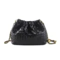 Borsa a sacco in pelle intrecciata nera con catena elegante e sfera d'oro, design cloud chic. - Nero