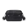 Detailed view of a stylish black leather men's crossbody bag with metal buttons and strap. - Black