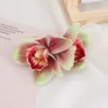 Detalle en primer plano de pinza de pelo con flor artificial de doble orquídea, tocado bohemio. - Rojo y Verde