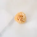 Detailed shot of the elegant champagne fabric artificial flower hair clip, delicate design. - Champagne