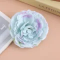 Detail close-up shot of artificial fabric flower hair clip in light blue color. - Aqua Blue