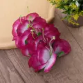 Detailed view of the vibrant artificial flower hair clip with gradient red petals. - Fuschia