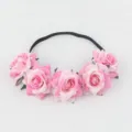 Close-up detail of the pink artificial rose flower headband, featuring soft fabric roses and band. - Pink