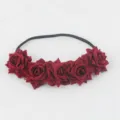 Close-up of dark red velvet rose headband detail showing five artificial flower charms. - Burgundy