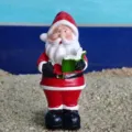 Close-up detail of a cute resin Santa Claus figurine holding a book, perfect for holiday decor. - Style D Holding Book
