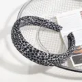 Gros plan détaillé d'un élégant serre-tête en tissu à motif léopard gris et noir sur un panier. - Léopard Gris
