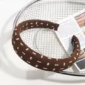 Gros plan détaillé d'un serre-tête large en tissu marron avec motifs et étiquette. - Imprimé Géométrique Brun
