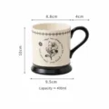 Keramische koffiekop met elegant bloemmotief, zwart handvat en onderkant, capaciteit 400ml. - Beker