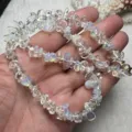 Natürlicher Edelstein Splitter Halskette Hand Detailansicht, glänzender Kristall Perlen Schmuck. - Synthetischer Opal