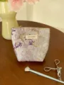 Detail view of the purple floral brocade cosmetic storage bag featuring elegant gold embroidery. - S / Purple Gold Floral