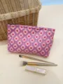Close-up detail of the pink floral jacquard cosmetic pouch fabric, styled with makeup brushes. - M / Pink Small Floral