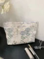 Close-up detail shot of the portable floral tapestry cosmetic pouch with neat zipper area. - L / Light Blue