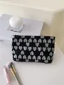 Detailed close-up of a black cosmetic bag featuring elegant silver 3D heart jacquard patterns. - M / Black