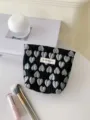 Detailed view of a black 3D silver heart cosmetic bag with branded tag and makeup brush props. - S / Black