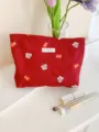 Close-up detail of the red cosmetic bag featuring cute gift box and mitten embroidery patterns. - L / Christmas Red