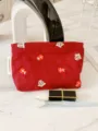 Christmas embroidered cosmetic bag detail showing festive gift patterns and side label. - M / Christmas Red