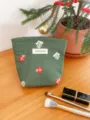 Green canvas Christmas embroidery cosmetic pouch detail view with gift pattern and brand label. - S / Christmas Green