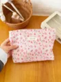 Close-up detail of the pink floral cosmetic pouch featuring delicate fabric and a stylish woven label. - L / Pink Flower