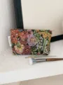Detailed view of vintage embroidered jacquard cosmetic bag with makeup brushes in scene. - M / Colorful Jungle