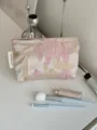 Detail view of the jacquard makeup pouch showcasing soft floral texture and elegant design. - M / Pink Floral Gold Leaf