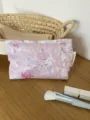 Close-up detail of the pink floral jacquard cosmetic pouch, showing vintage fabric texture. - M / Purple Floral