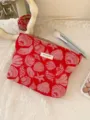 Close-up view of red shell jacquard cosmetic pouch detail displayed on white lace background. - L
