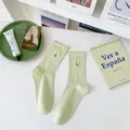 Light green cotton mid-calf socks featuring cute ruffled edges and delicate tulip embroidery. - One Size / Green